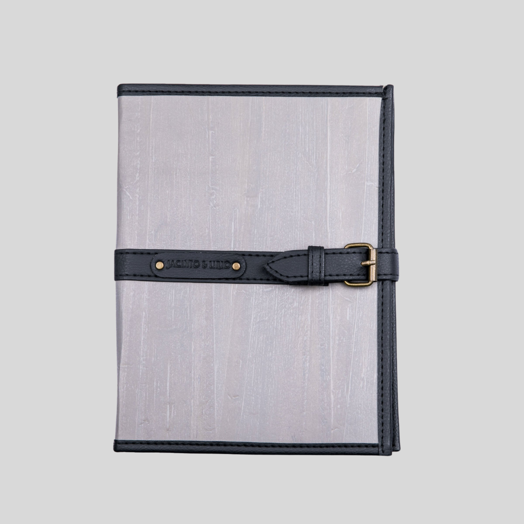 A coal gray vegan leather journal with dark gray hem and belt buckle closure.