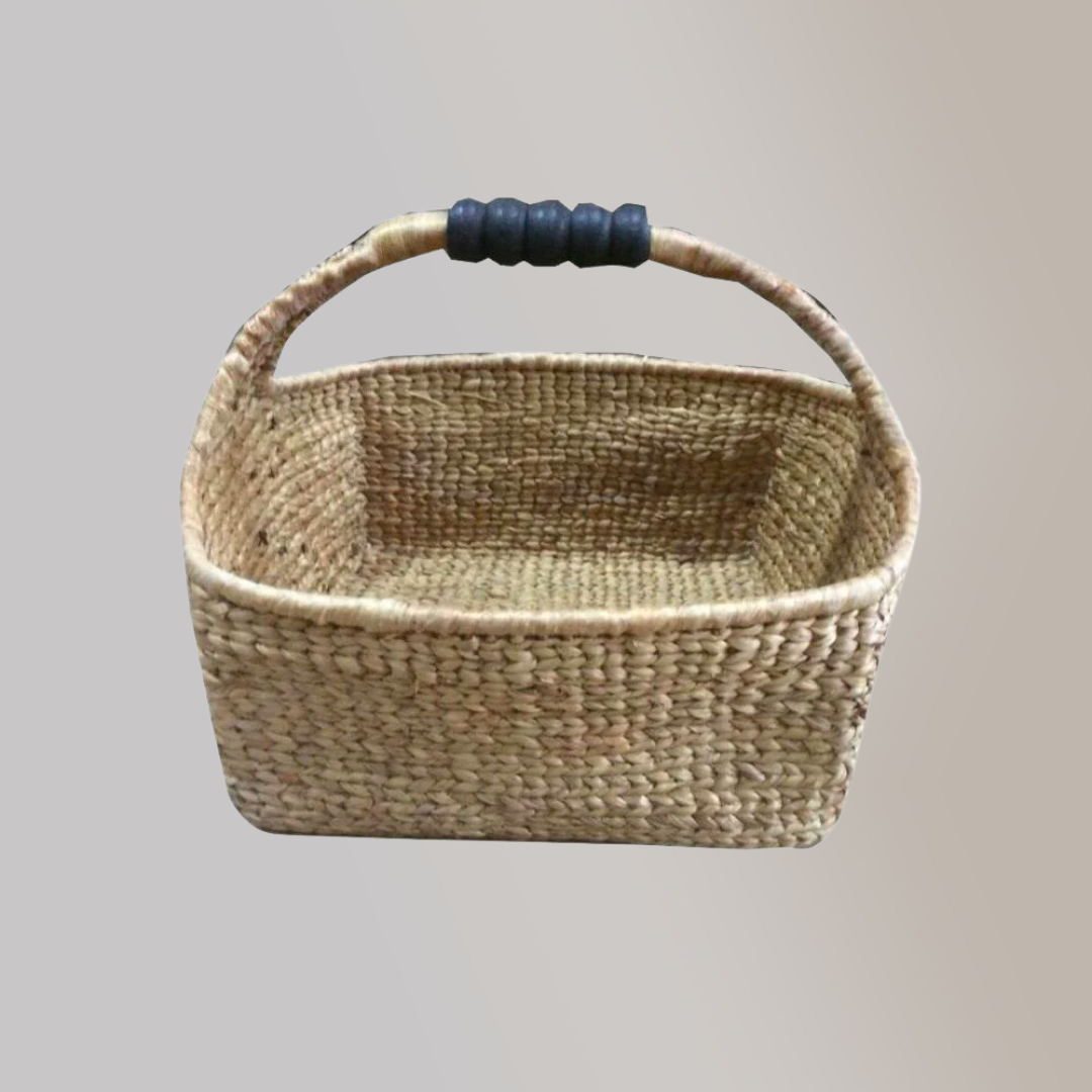 A woven basket made out of dried water hyacinth stalks with a blue leather accent tied to its handle.