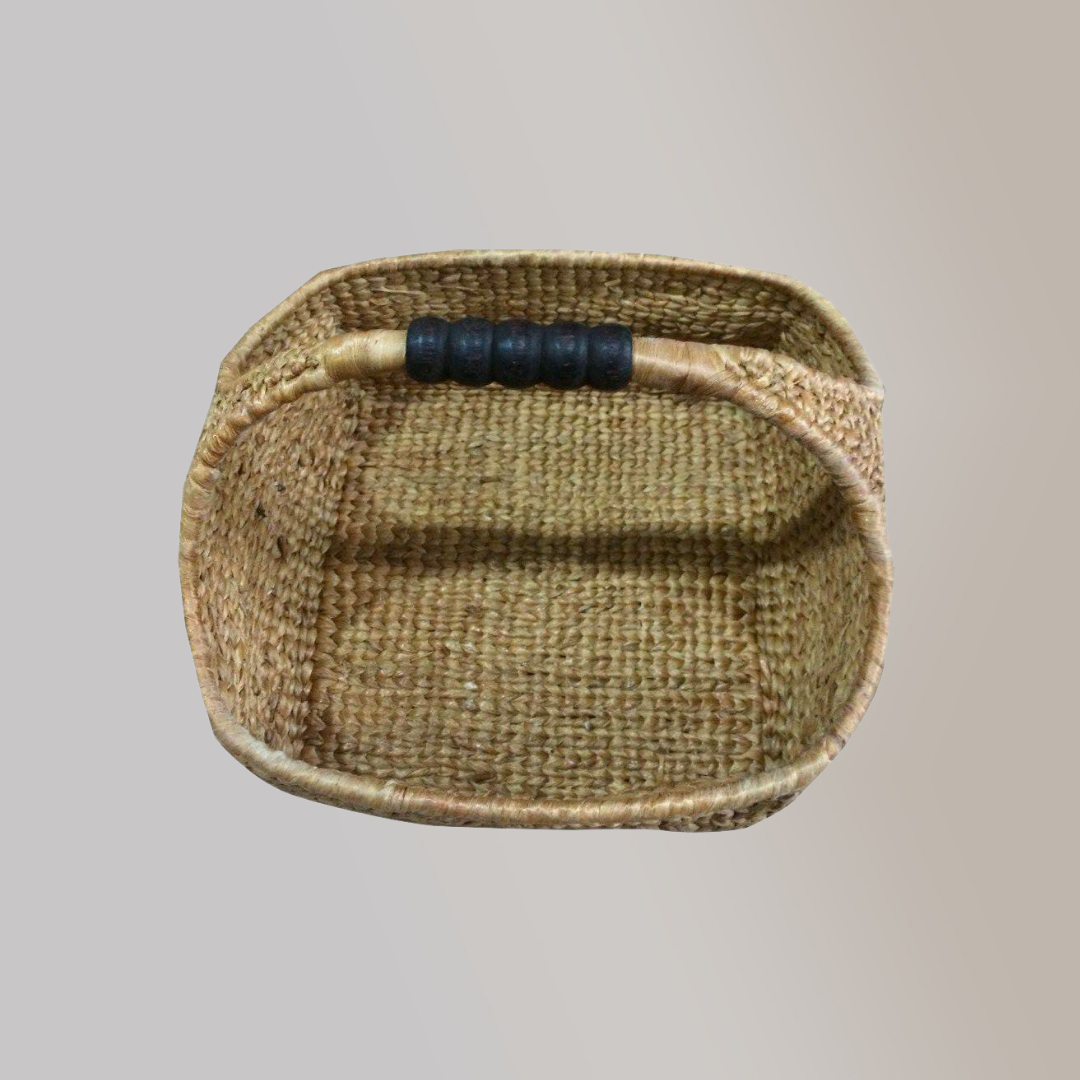 A woven basket made out of dried water hyacinth stalks with a blue leather accent tied to its handle.