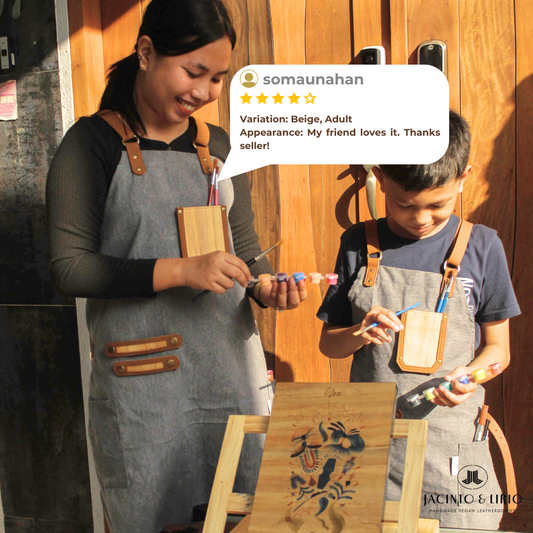 A mother and son wearing matching aprons and painting.