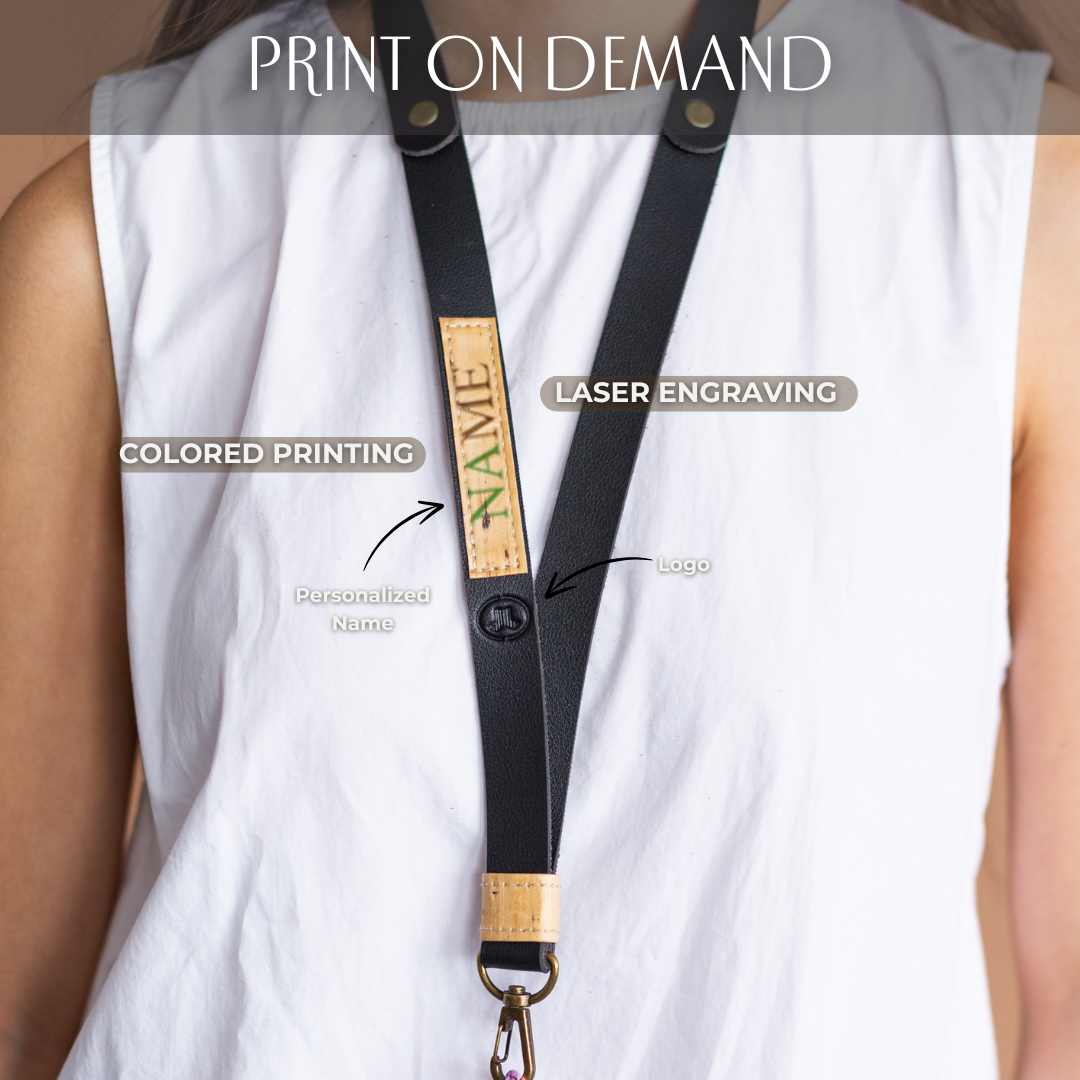 A laser engraved and color printed design on a black vegan leather lanyard.