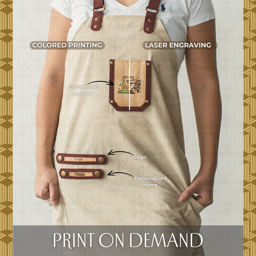 Woman wearing cream colored apron that has vegan leather accents and chest pocket which has colored printing and laser name engraving.