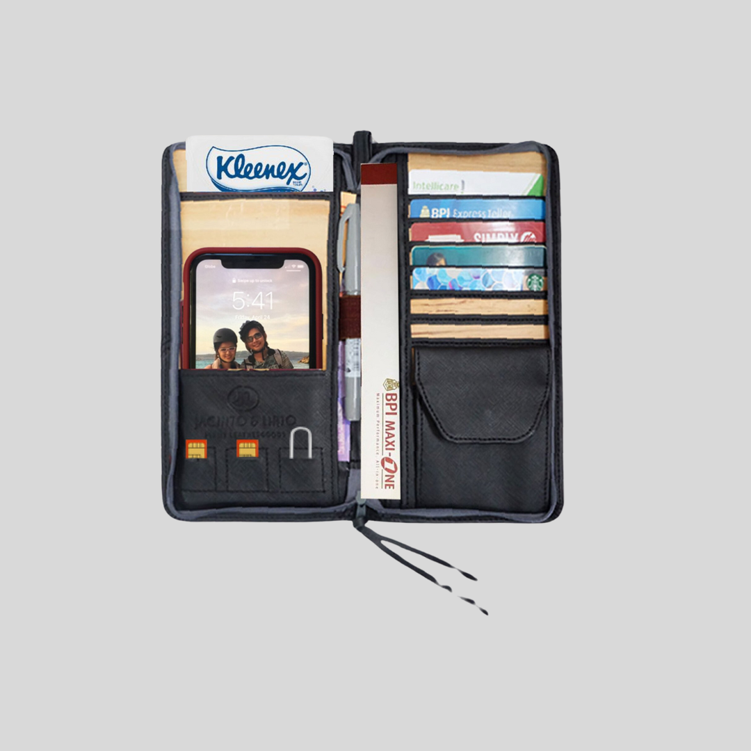 The inside of a black wallet made of vegan leather, that has multiple card slots, a coin pocket, a checkbook tucked into one of the compartments, a phone inside one of the pockets, and many more items.