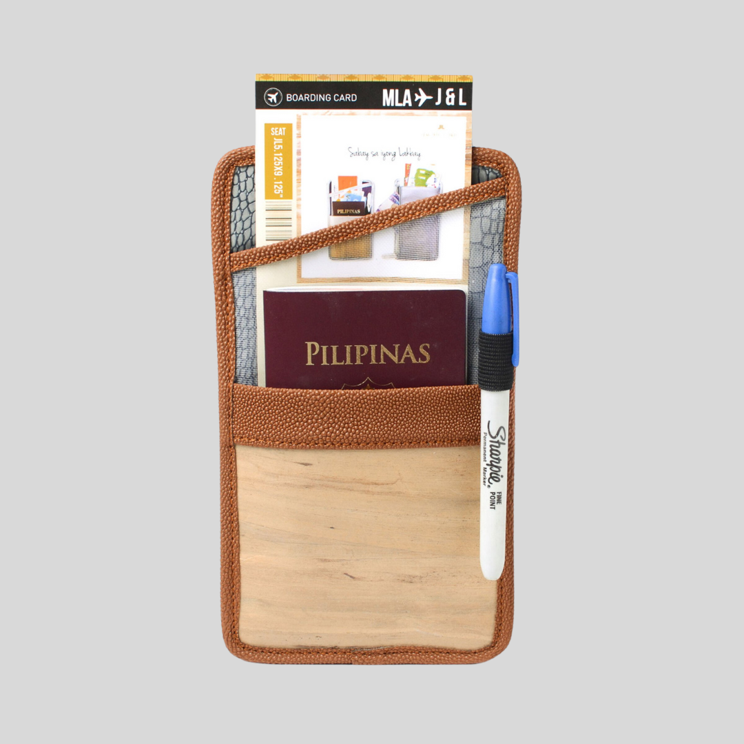 A brown vegan leather documents holder holding a Philippine passport as well as a boarding ticket in a separate compartment.