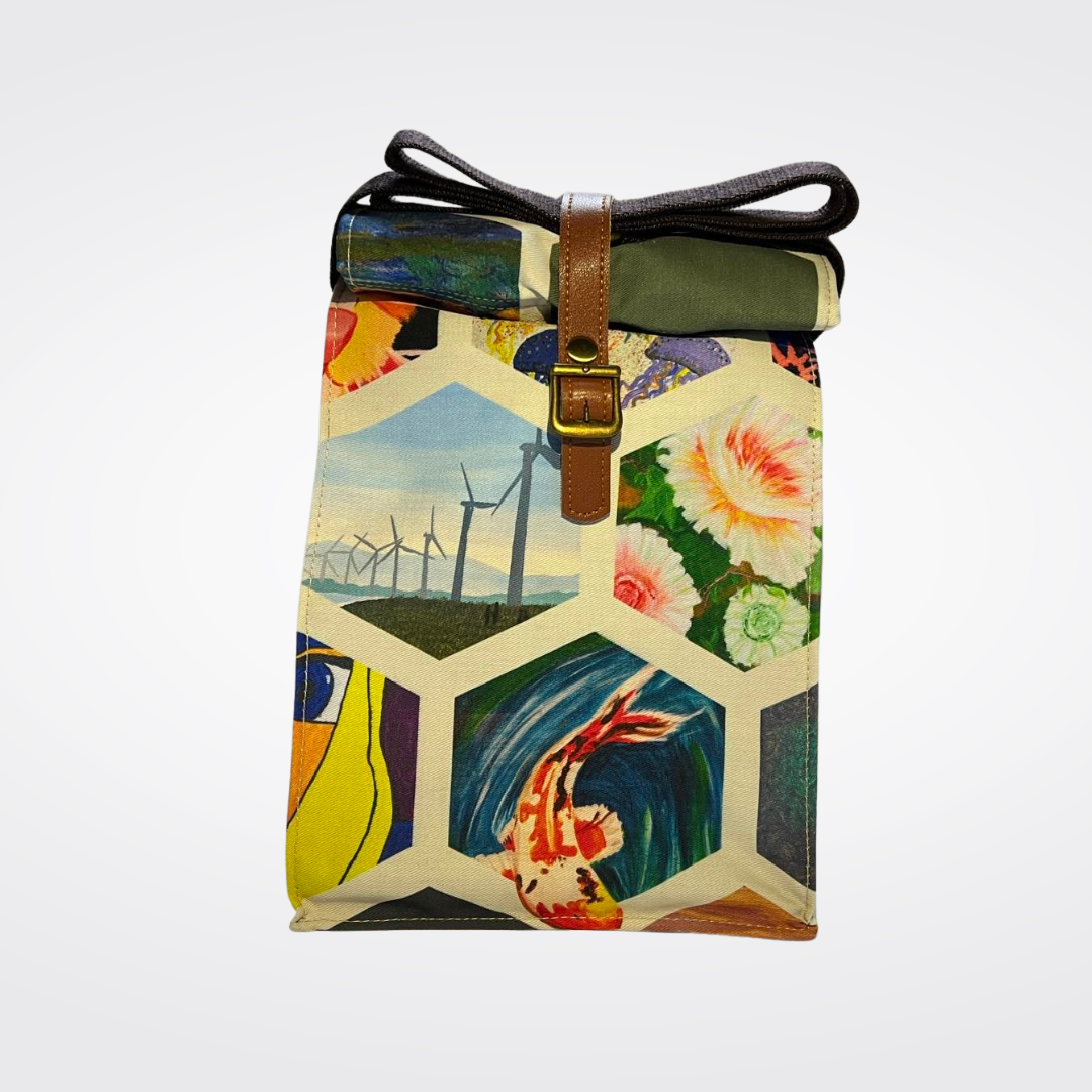 Front view of a unique roll-top tote bag featuring a hexagonal art collage, including a vibrant koi fish in blue water, detailed white and pink flowers, and a wind turbine landscape, secured with a brown vegan leather strap and buckle.