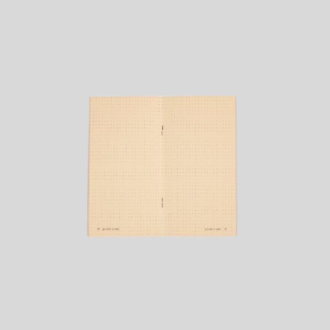 A notebook with dotted pages that is opened.