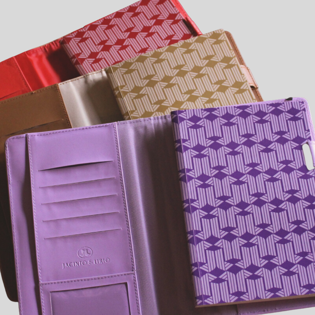 3 Perseverance Journals by Jacinto & Lirio stacked on top each other, in colors purple, brown, and red.