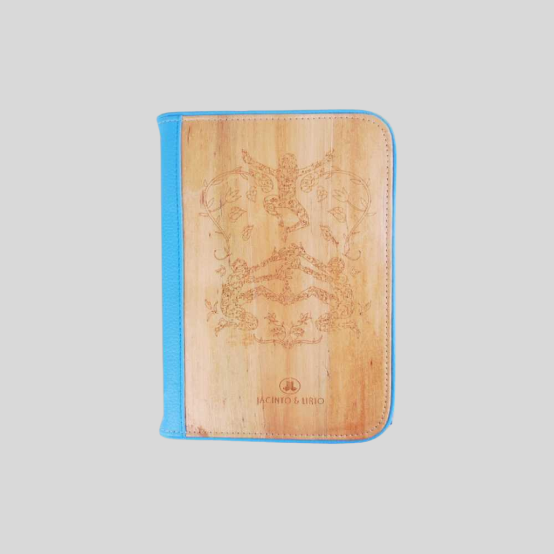 A vegan leather notebook with teal blue leather hemming and an intricate drawn design on its cover.