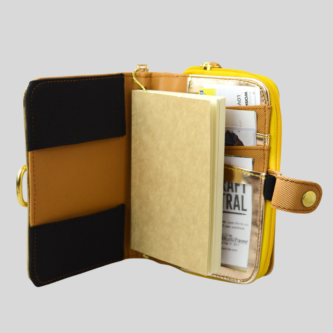 A vegan leather journal with many papers stored in its built=in compartments.