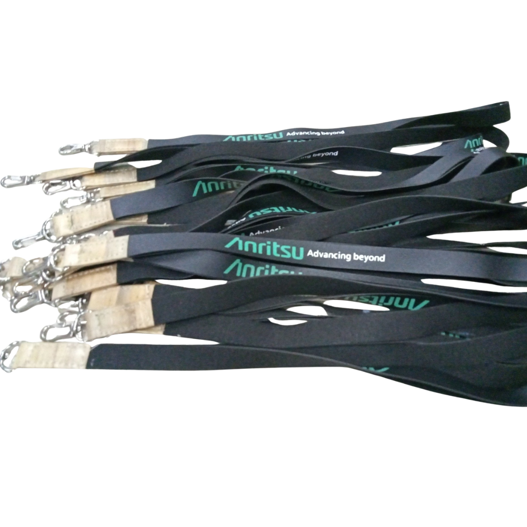Bulk quantity of custom black Anritsu lanyards with green logo print, suitable for corporate events, conferences, and promotional merchandise. Featuring green "Anritsu Advancing Beyond" text, light brown faux vegan leather accents, and silver swivel clips.