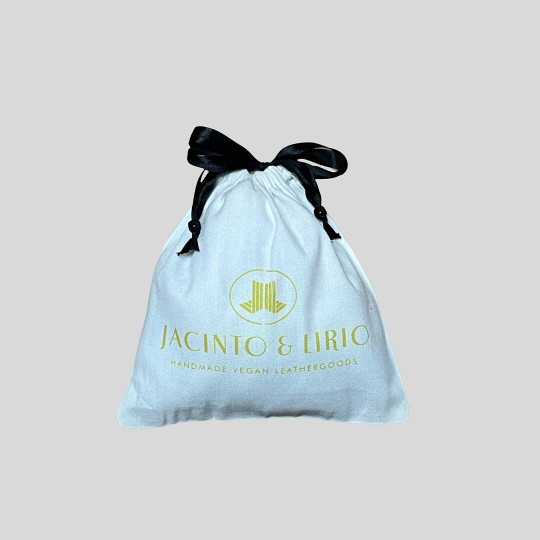 drawstring eco-bag with a white fabric design, black ribbon closure, and branding for handmade vegan leathergoods.