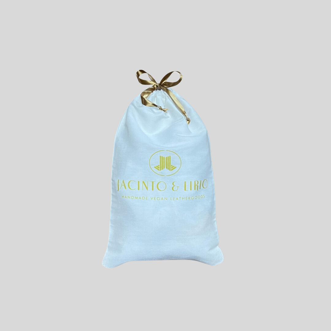 drawstring eco-bag with a white fabric design, gold ribbon closure, and branding for handmade vegan leathergoods.