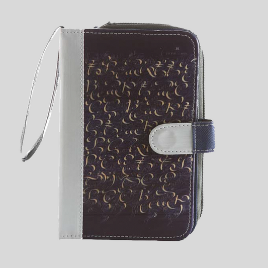 A thick dark brown leather notebook with a white leather spine and closing flap, and intricate baybayin handwriting on the front.