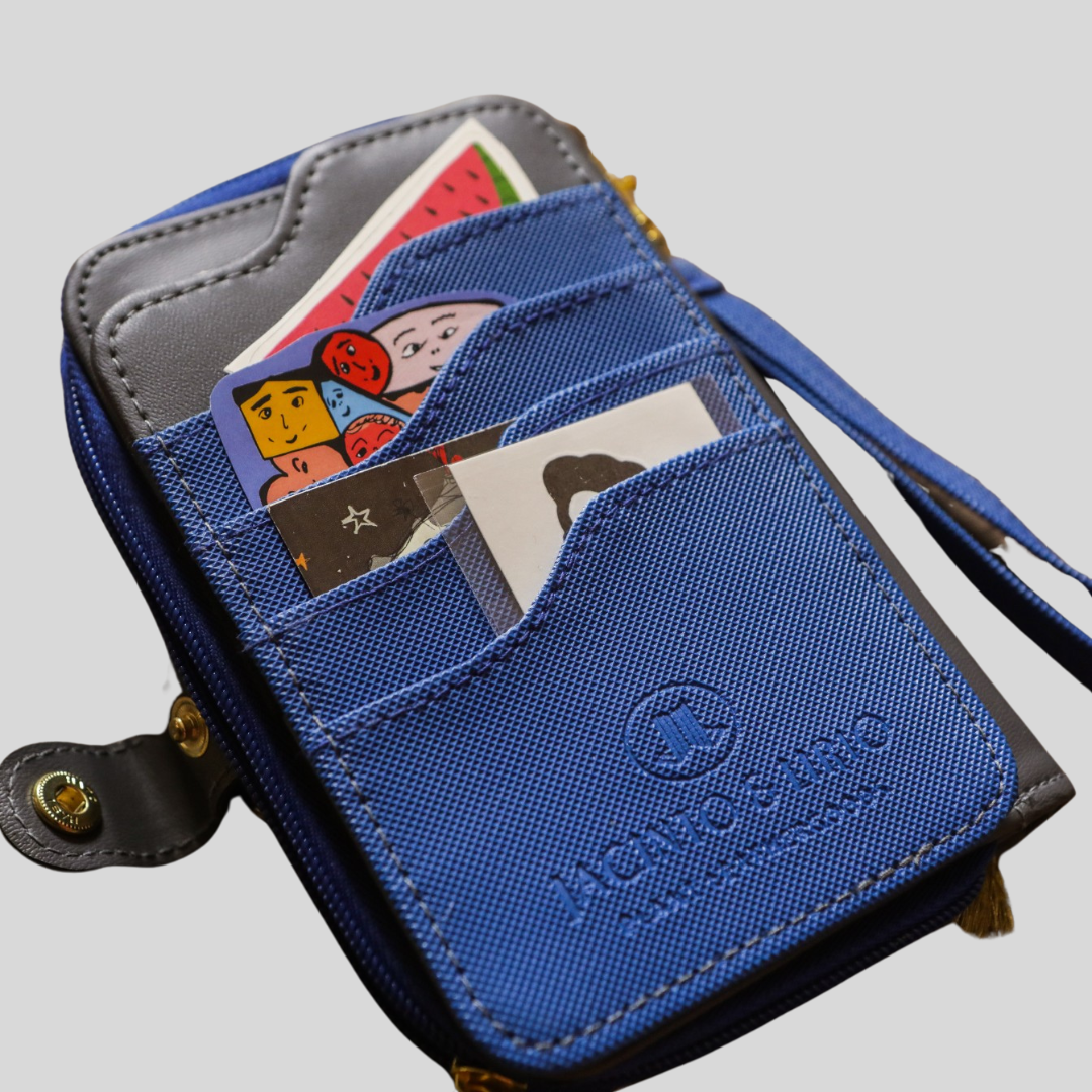 A blue textured vegan leather card case holding various images, stickers, and cards.