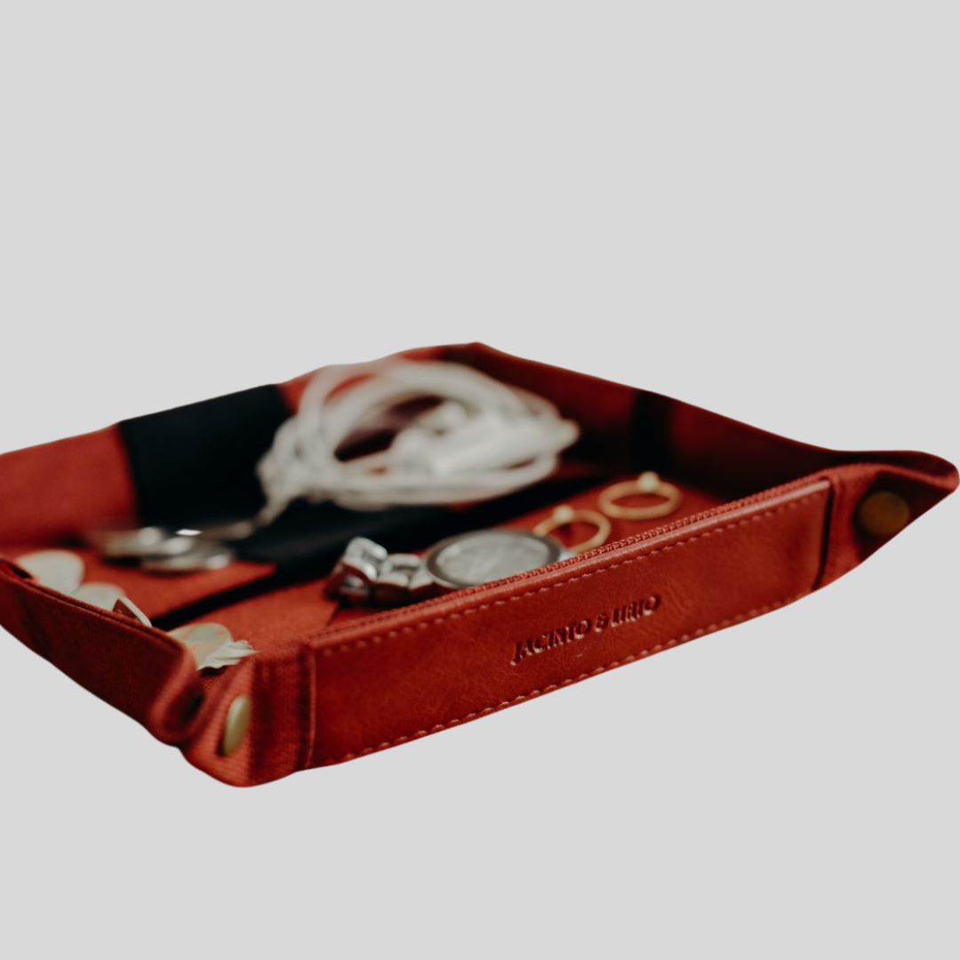 A deep red vegan leather valet tray with the Jacinto & Lirio logo dry-embossed on one of the sides.
