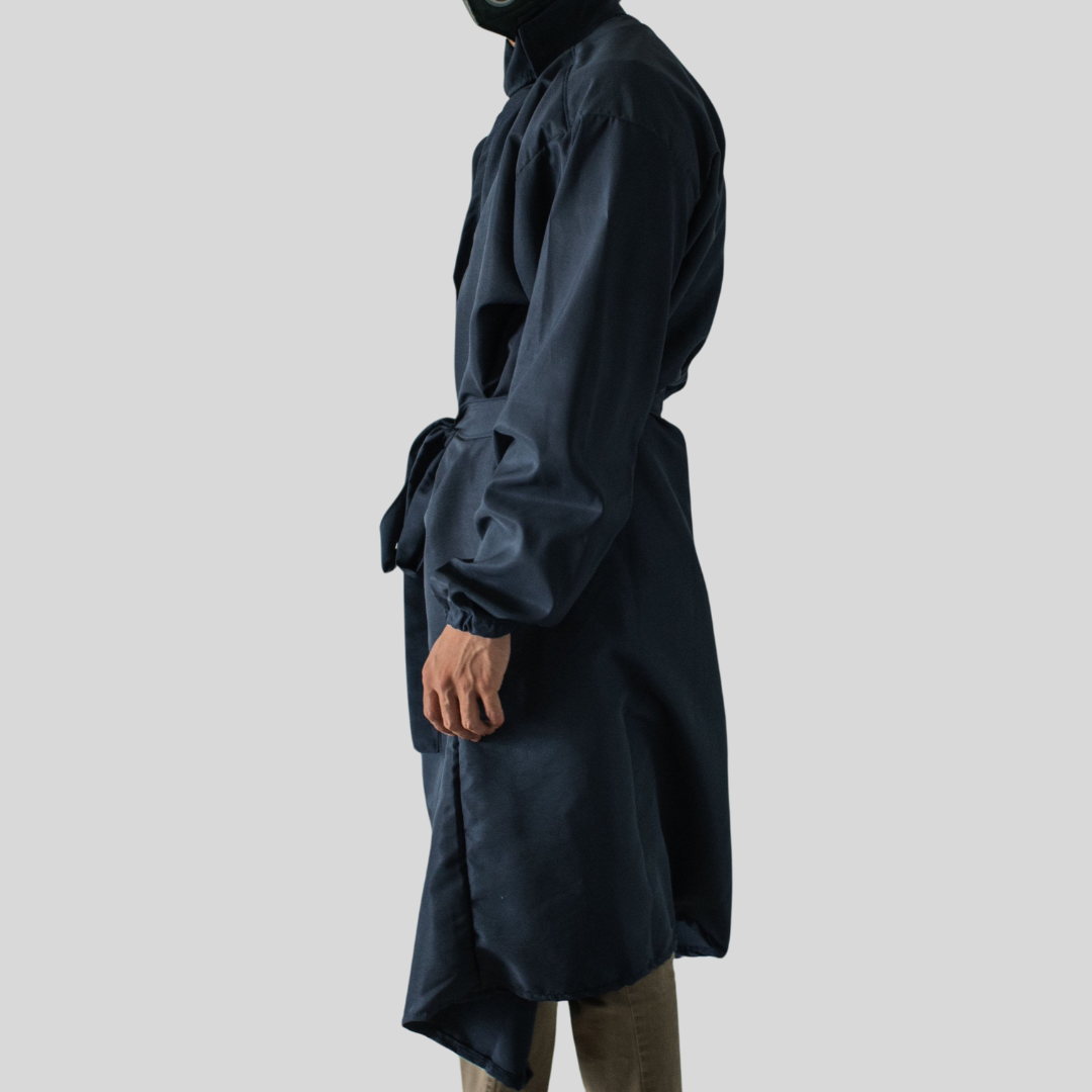 The side view of a man wearing a dark blue full-body protective robe with a belt tied in front.