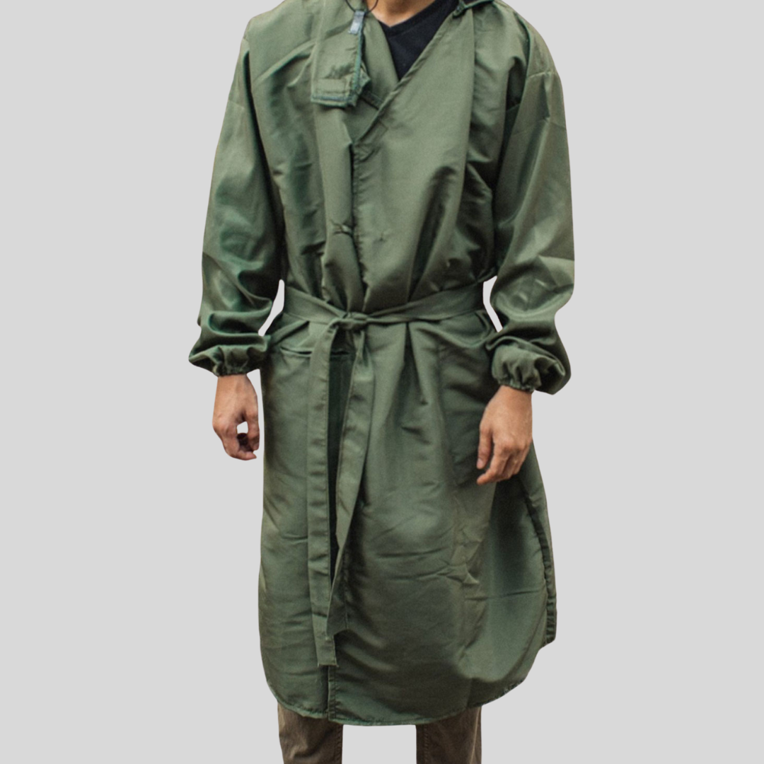 An individual wearing a stylish sage green PPE suit that is tied closed by its built-in belt.