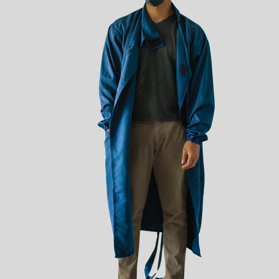 A model stylishly wearing a shin-length kimono PPE suit as a trench coat by leaving it unbuttoned.