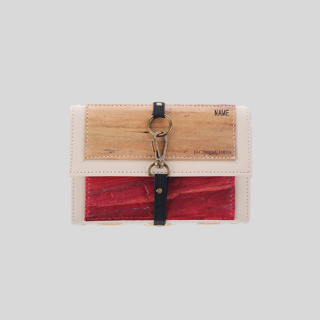A vegan leather passport case and mini notebook in classic colors (beige, cream, red) with a black garter and metal hook closure for security, and a laser engraved name on the top right corner.