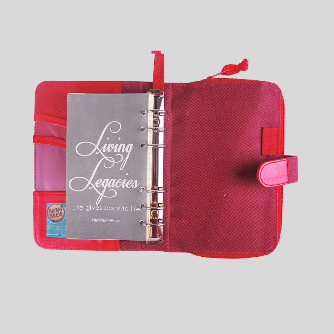 The interior of a pink leather refillable notebook binder, showing a title page and card compartments on the inside flap.