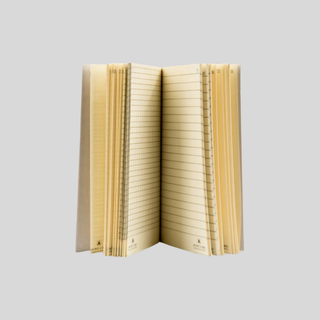 A notebook partially opened, showing lined cream pages