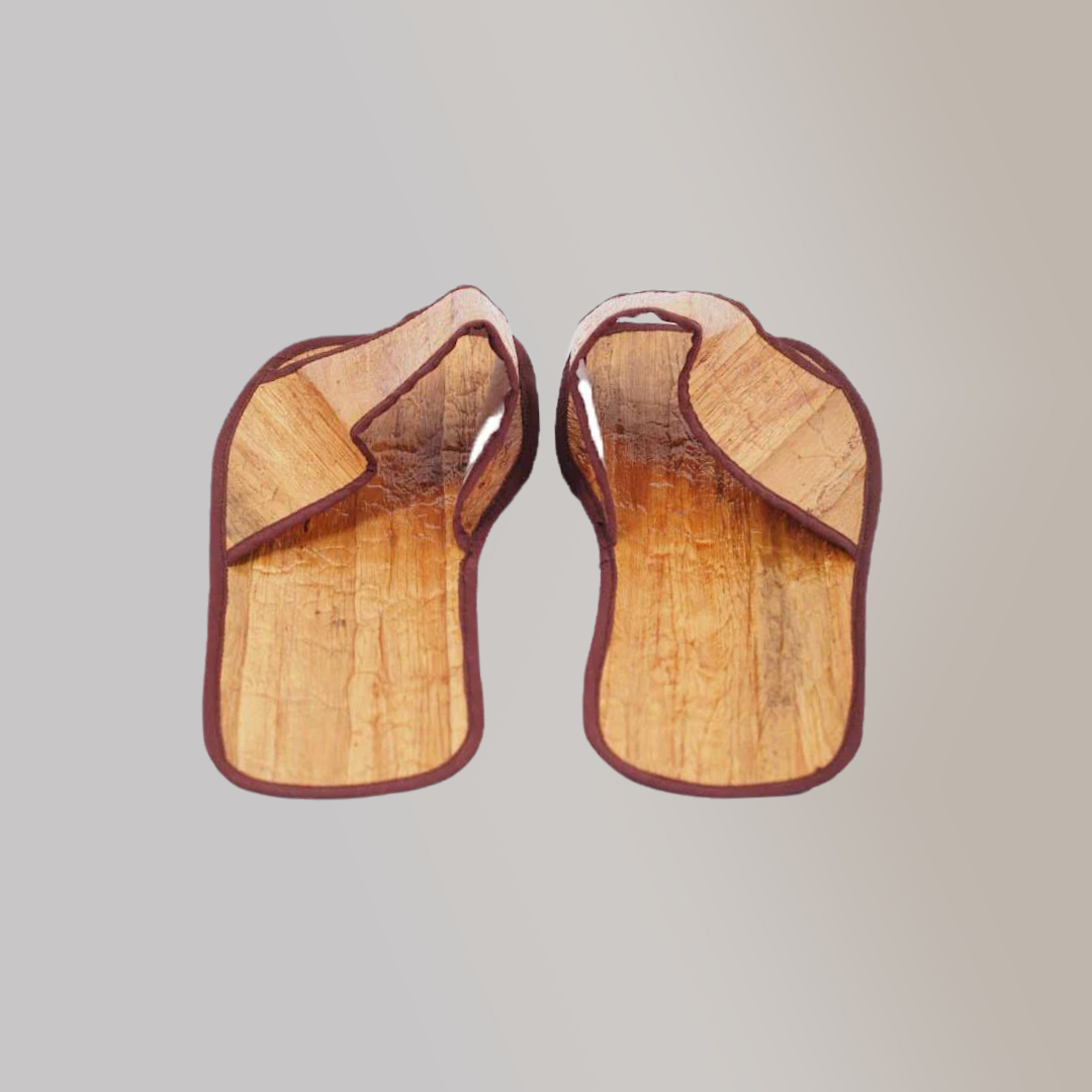 A pair of hotel slippers made out of vegan leather which gives them a nice wood-like design.