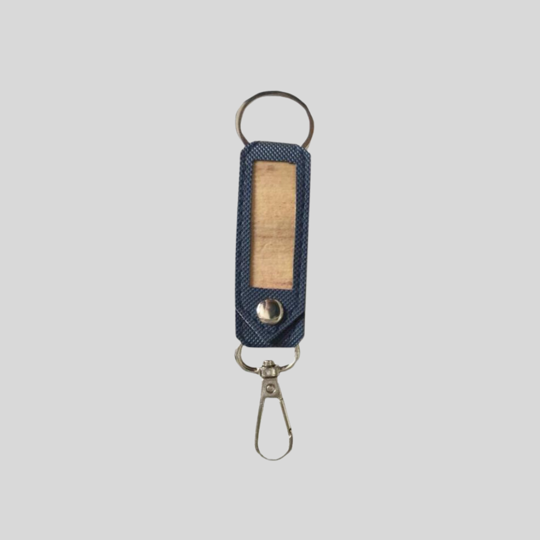 A stylish leather key holder that comes in a navy blue color with a beige accent in the middle