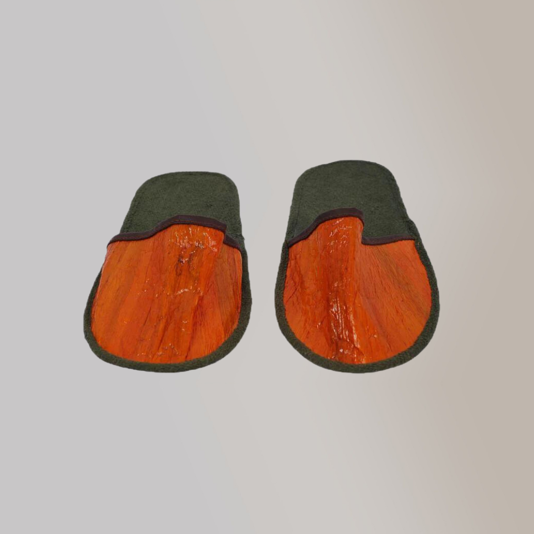 Two toned hotel slippers made of vegan leather, with bright orange on the foot cover and gray fabric for the sole.