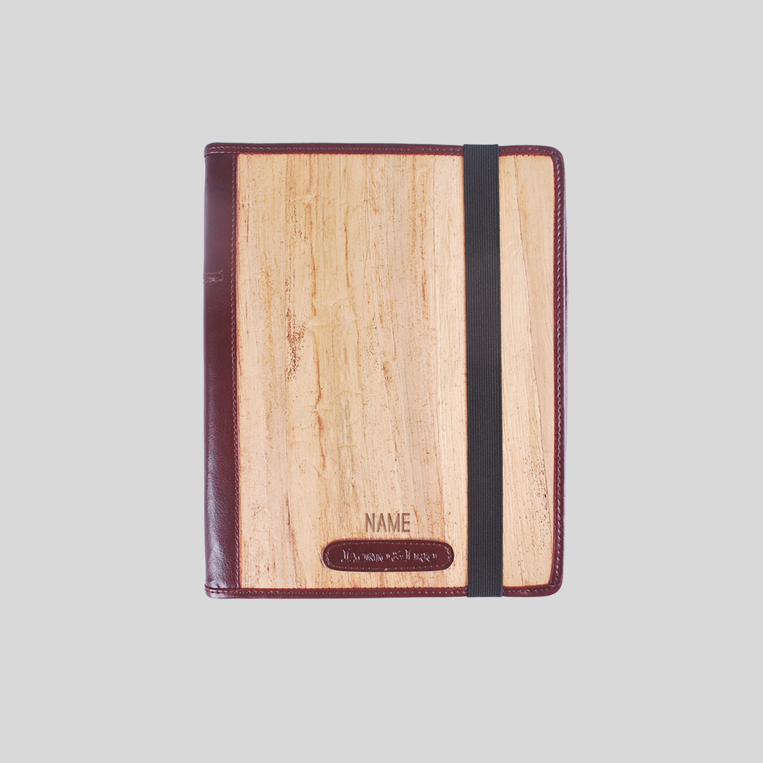 beige and red vegan leather ipad case with a black garter, name engraving on the bottom, and red leather accents.