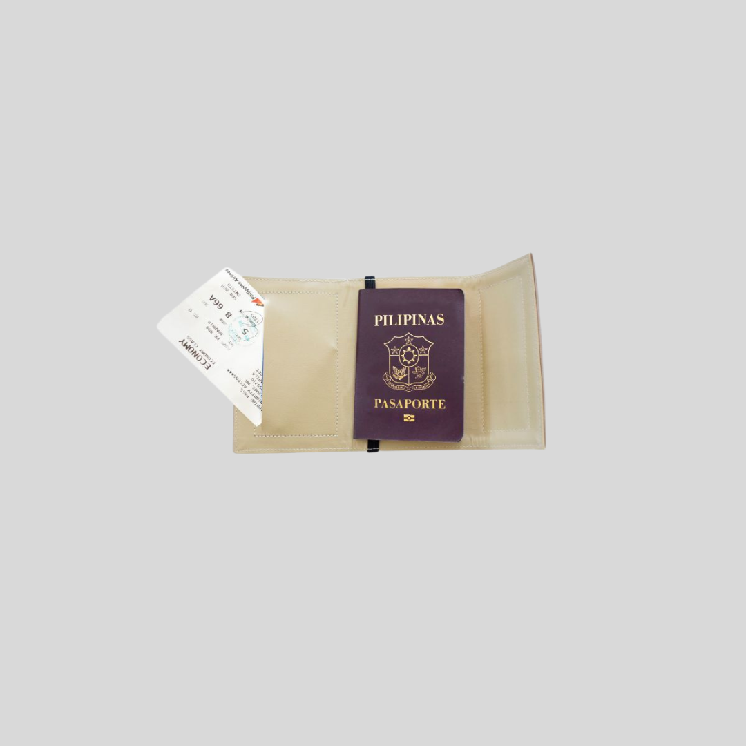 Beige passport holder containing a Philippine passport, and a plane boarding ticket peeking out from a side pocket.