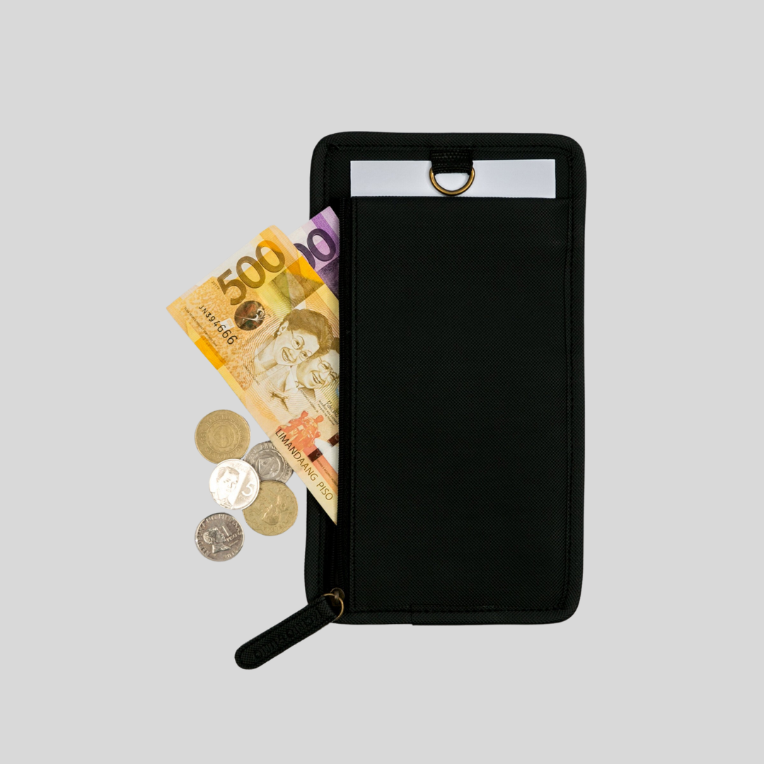 Some bills and coins spilling out of a rectangular black wallet.