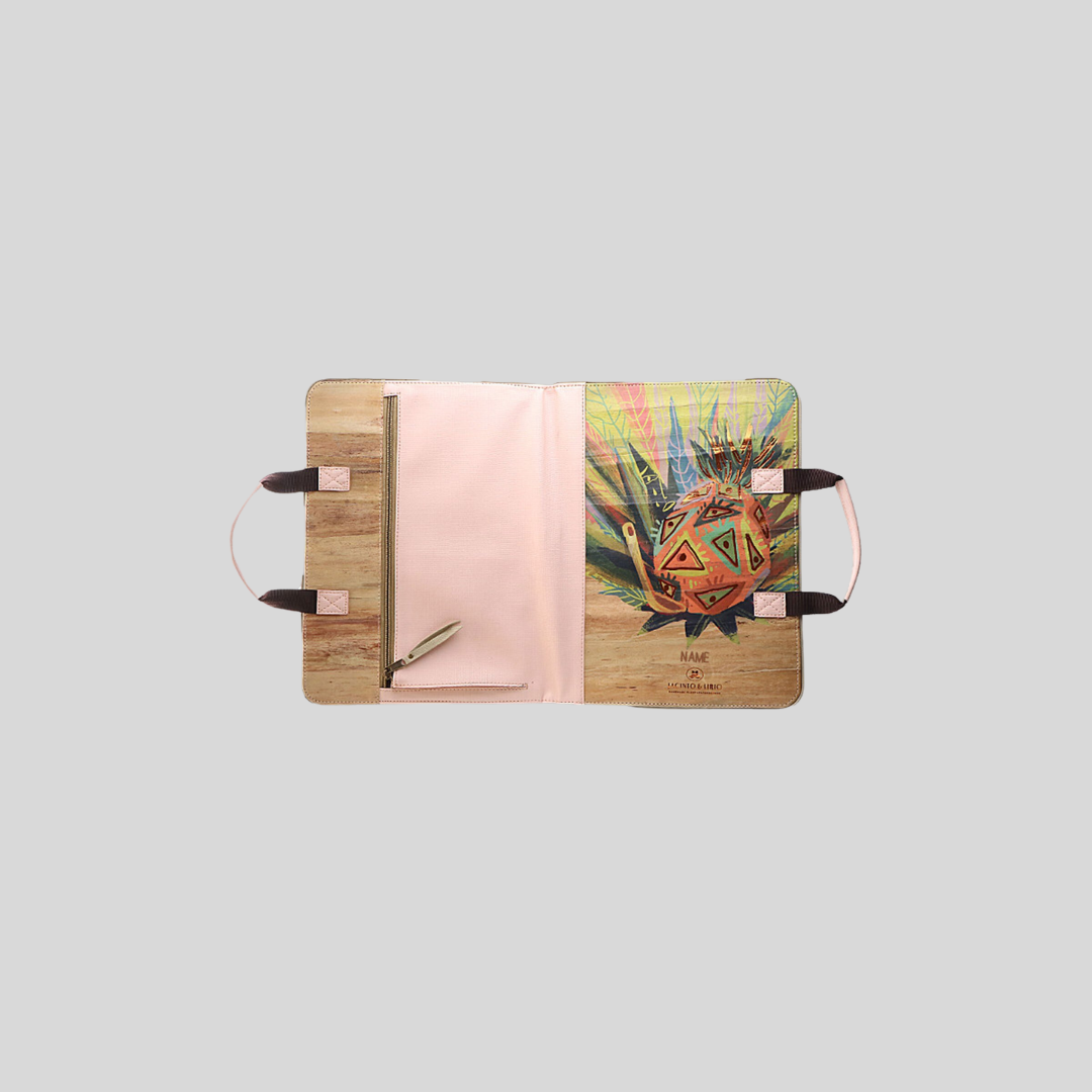 The whole exterior side of a vegan leather planner laid flat, showing the built-in fabric pink-colored pouch on its back as well as the vibrant cover art.