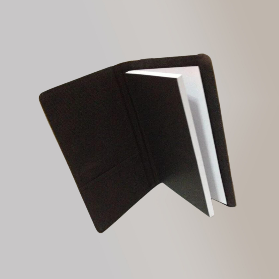 A black journal standing upright and opened, with a pocket compartment in its inner flap.