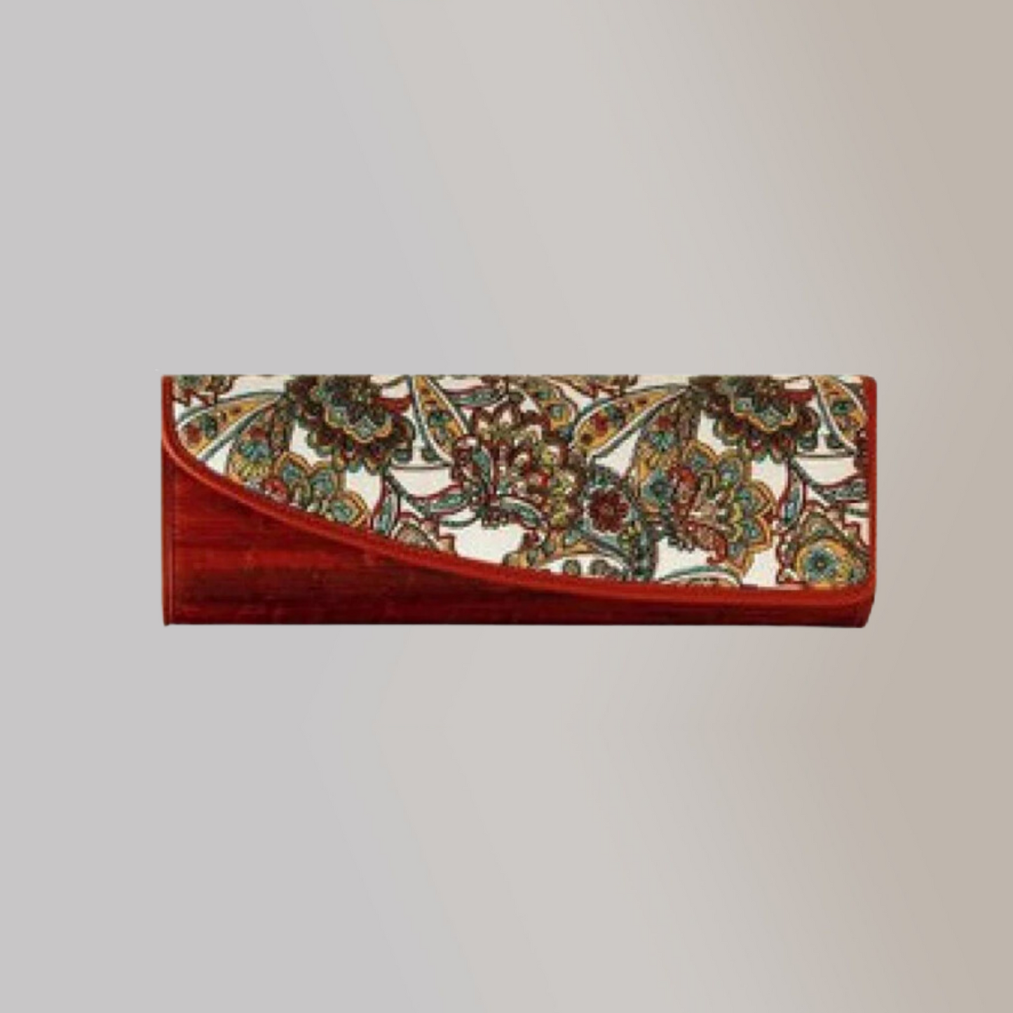 A wine red clutch made out of water hyacinth vegan leather, with an asymmetrical front flap that has intricte and colorful embroidery on its front.
