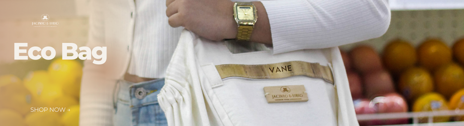 A person with a gold watch carrying a white tote bag with their name engraved.