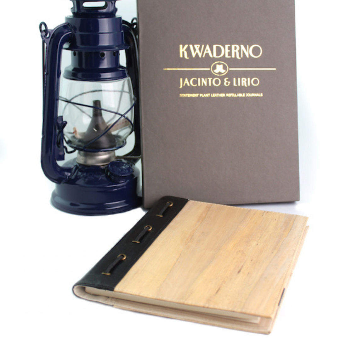 A vintage aesthetic vegan leather journal along with a page insert, next to an old school oil lamp.