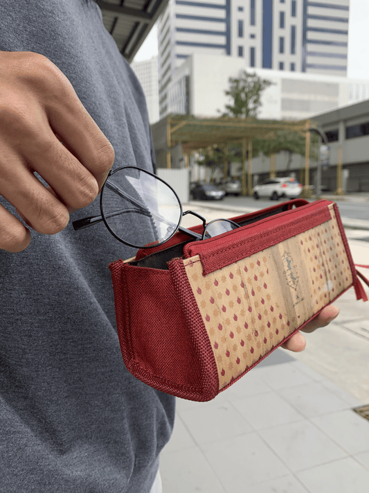 A red and wood colored glasses case being opened.