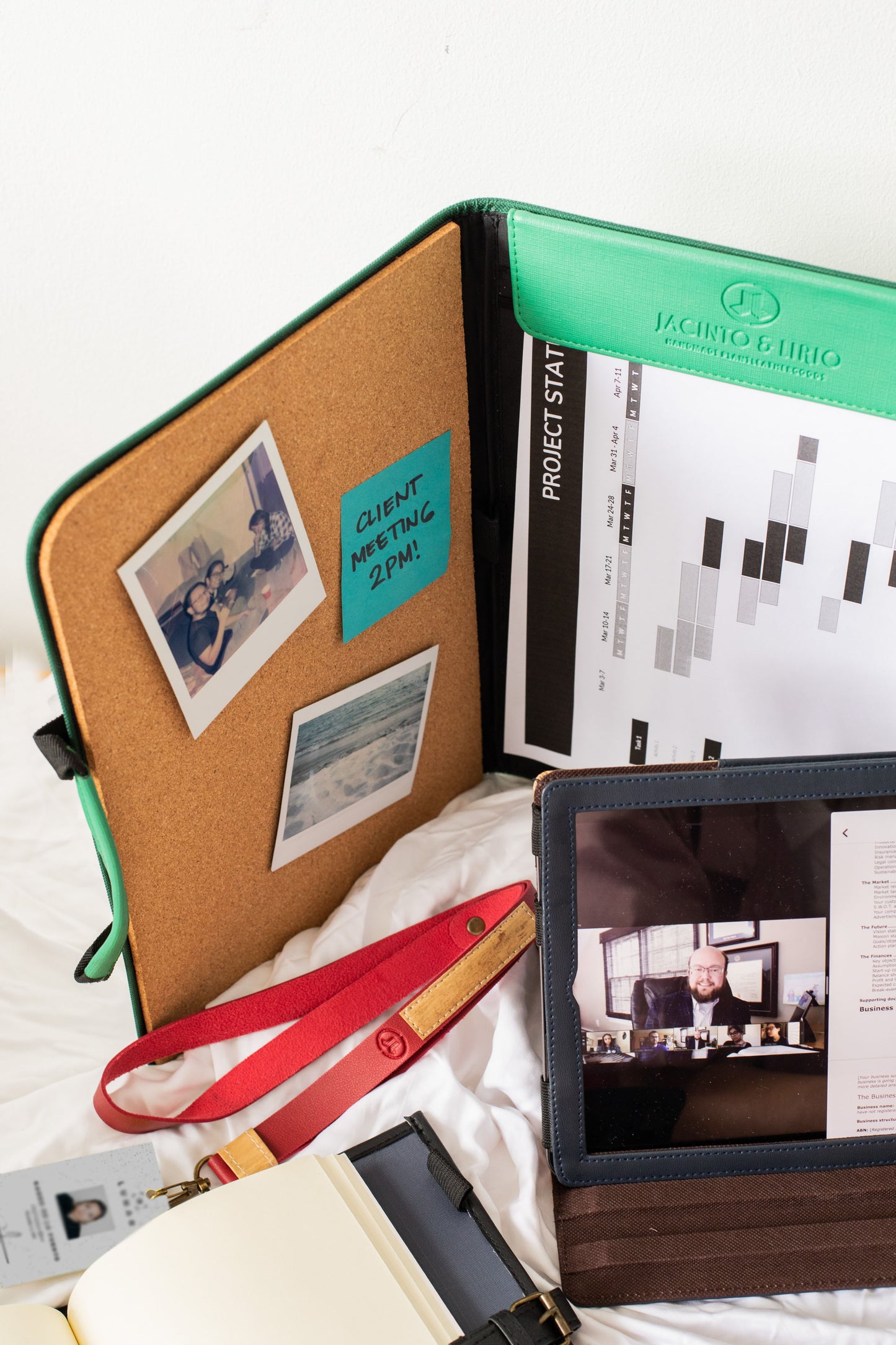 A convenient vegan leather planner that has a built-in corkboard with polaroids attached to it.
