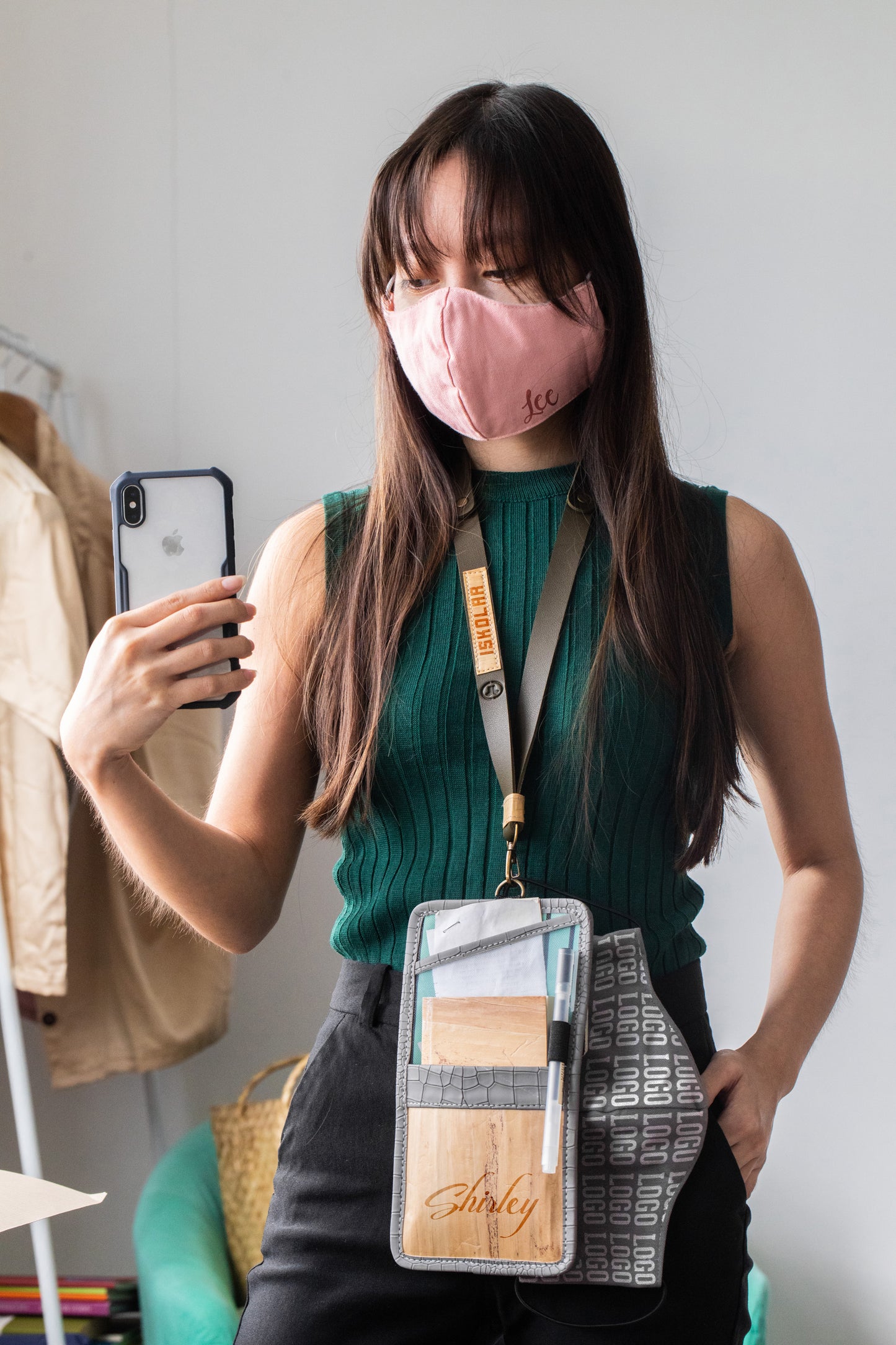 A woman taking a mirror selfie with a vegan leather lanyard.