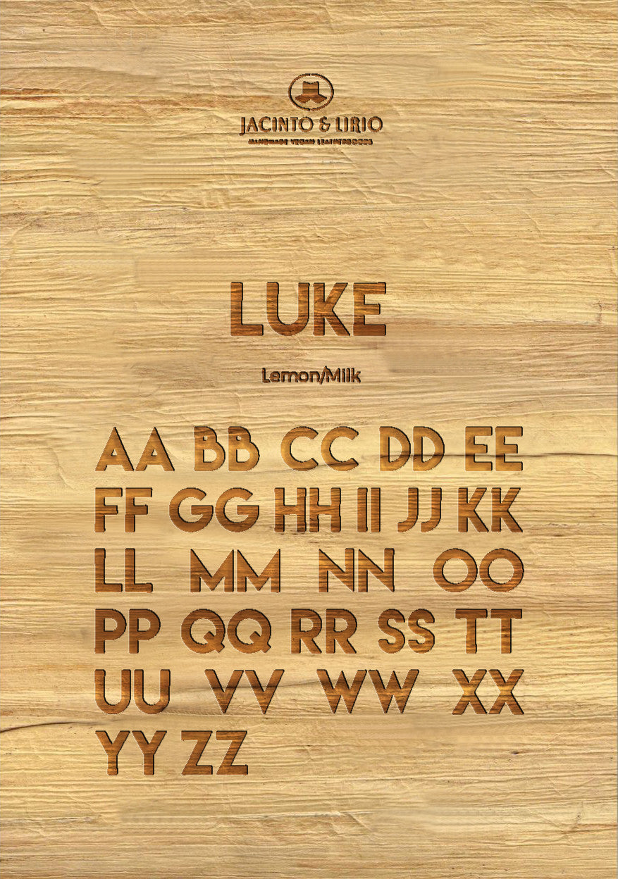 The name "Luke" laser engraved on a piece of vegan leather along with its the uppercase and lowercase alphabet engraved with the same font to showcase the full range.