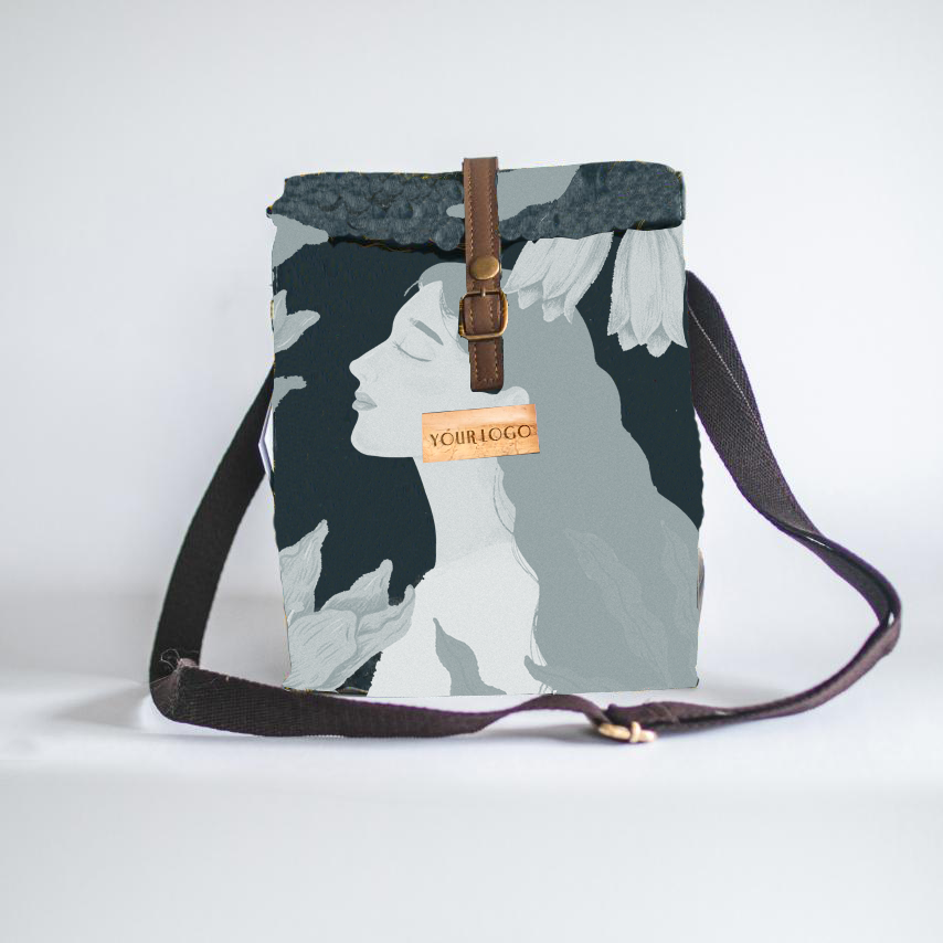 A cross-body strap lunch bag with a greyscale design of a woman and flowers on its front.
