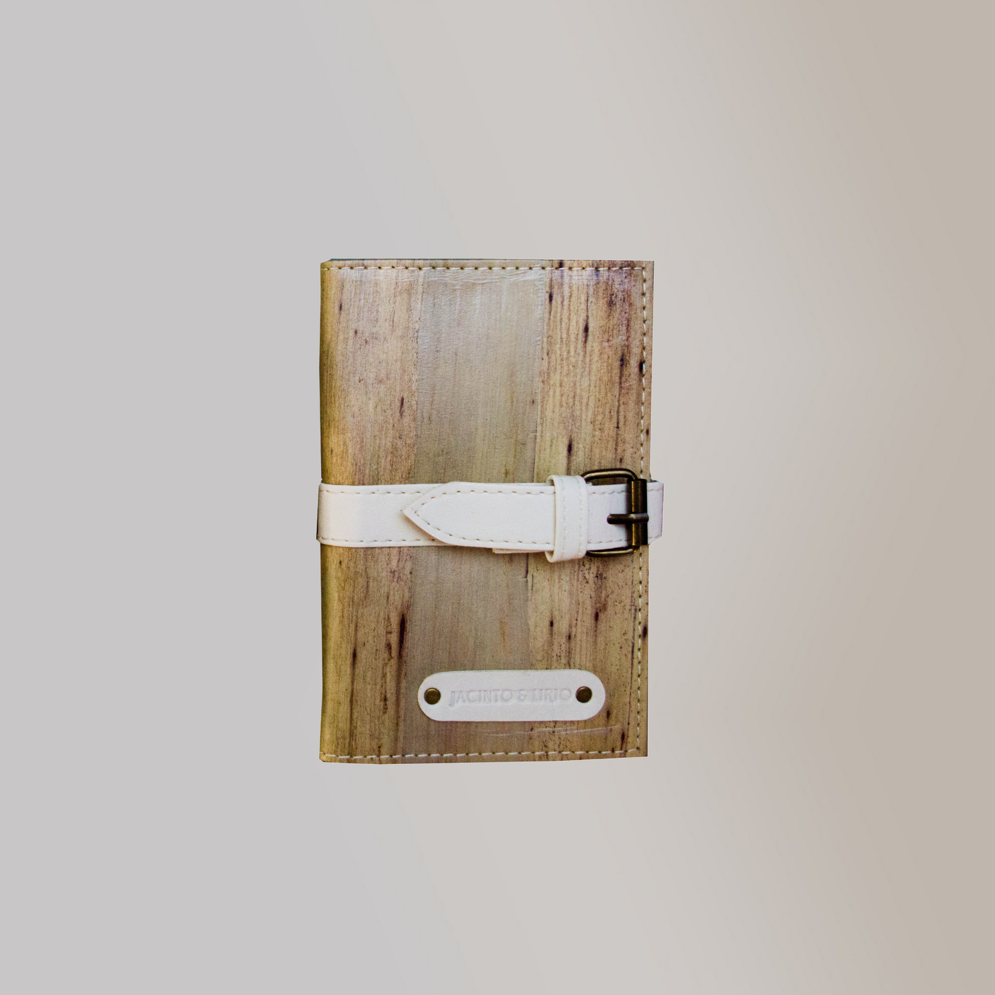 A vegan leather journal with a cool white leather belt buckle closure.