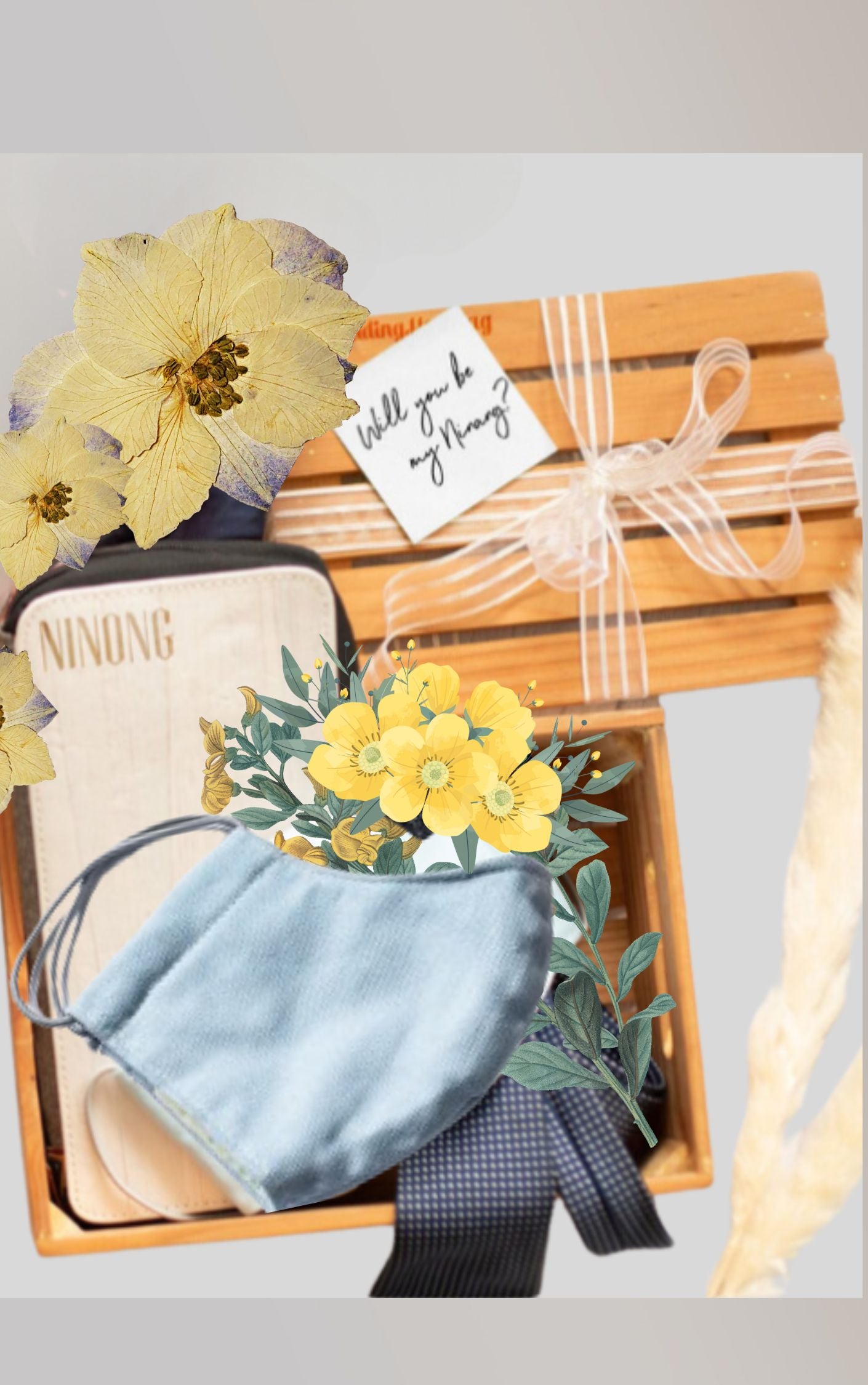 A gift set inside a wooden crate containing: a pastel pink travel wallet and notebook, and a sky blue fabric mask, along with yellow flowers and blue ribbons for decoration.