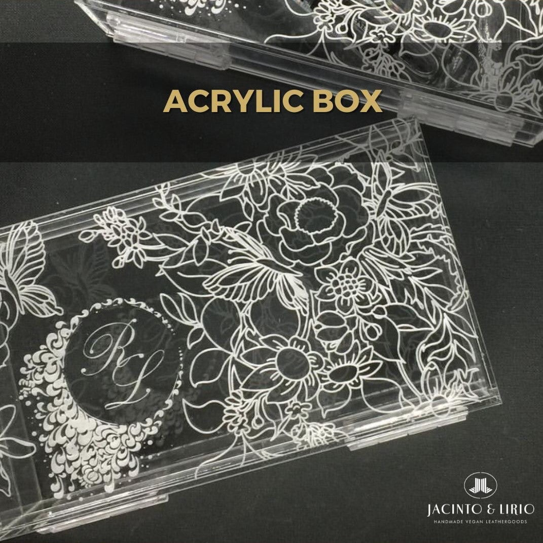 A clear acrylic box with white designs of flowers and a logo on it.