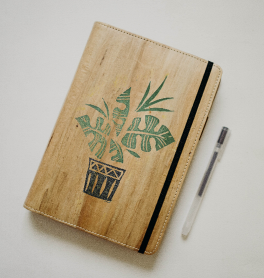 A design of a monstera plant on a leather journal.
