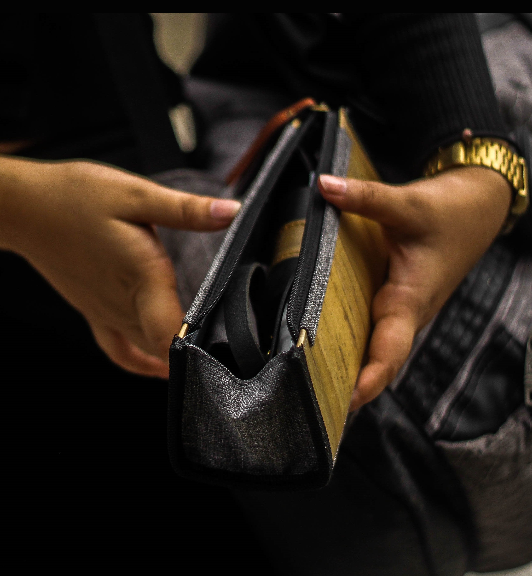 A woman holding open her gray and brown wallet