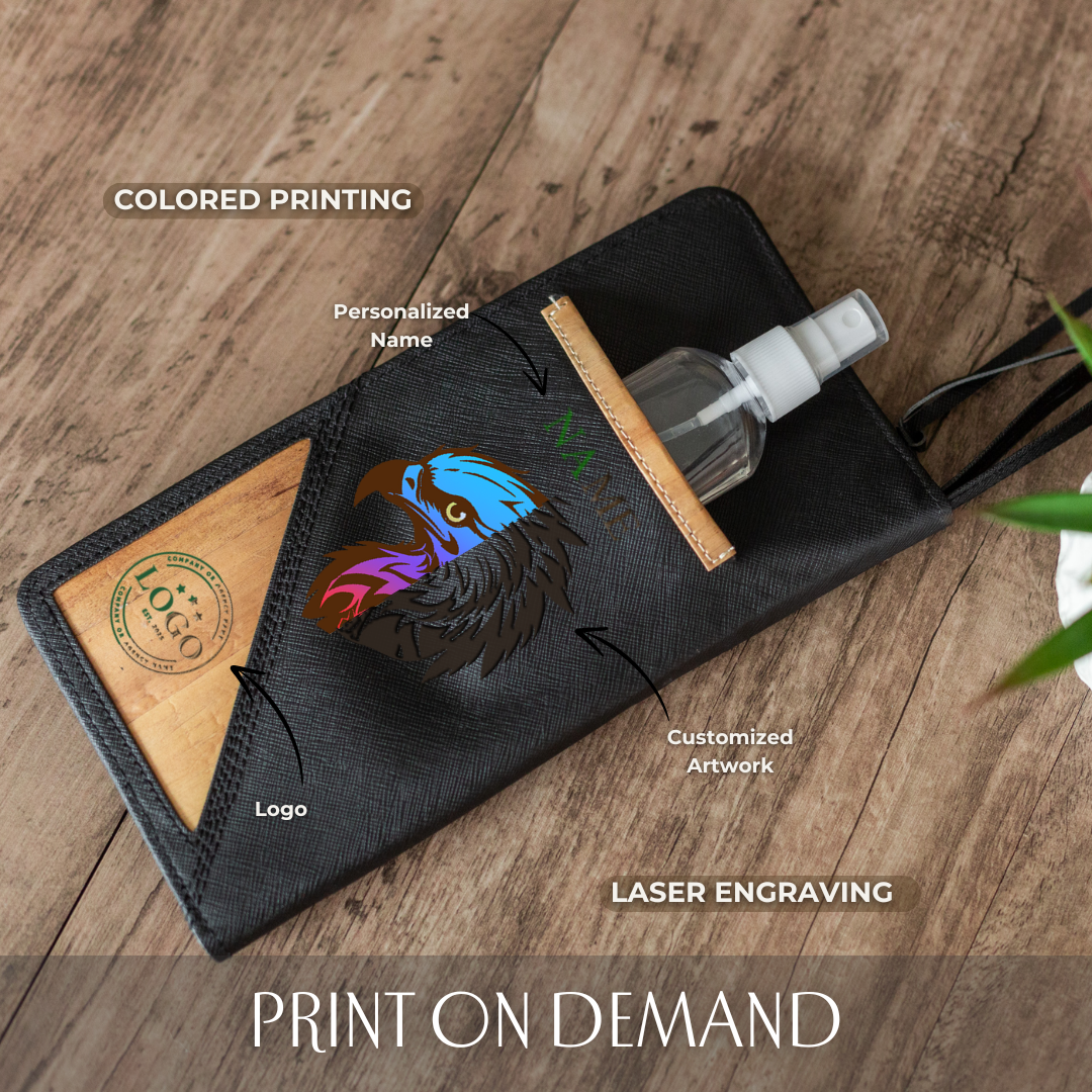 Black rectangular leather travel wallet with an inlaid pocket holding mini hand sanitizer, a ombre print of an eagle in the center, and a vegan leather corner with a logo printed on it.