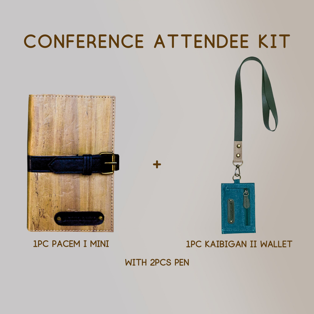 A mini vegan leather journal with a dark blue leather belt buckle closure paired with a wallet ID lanyard of the  same color scheme, and two pens.