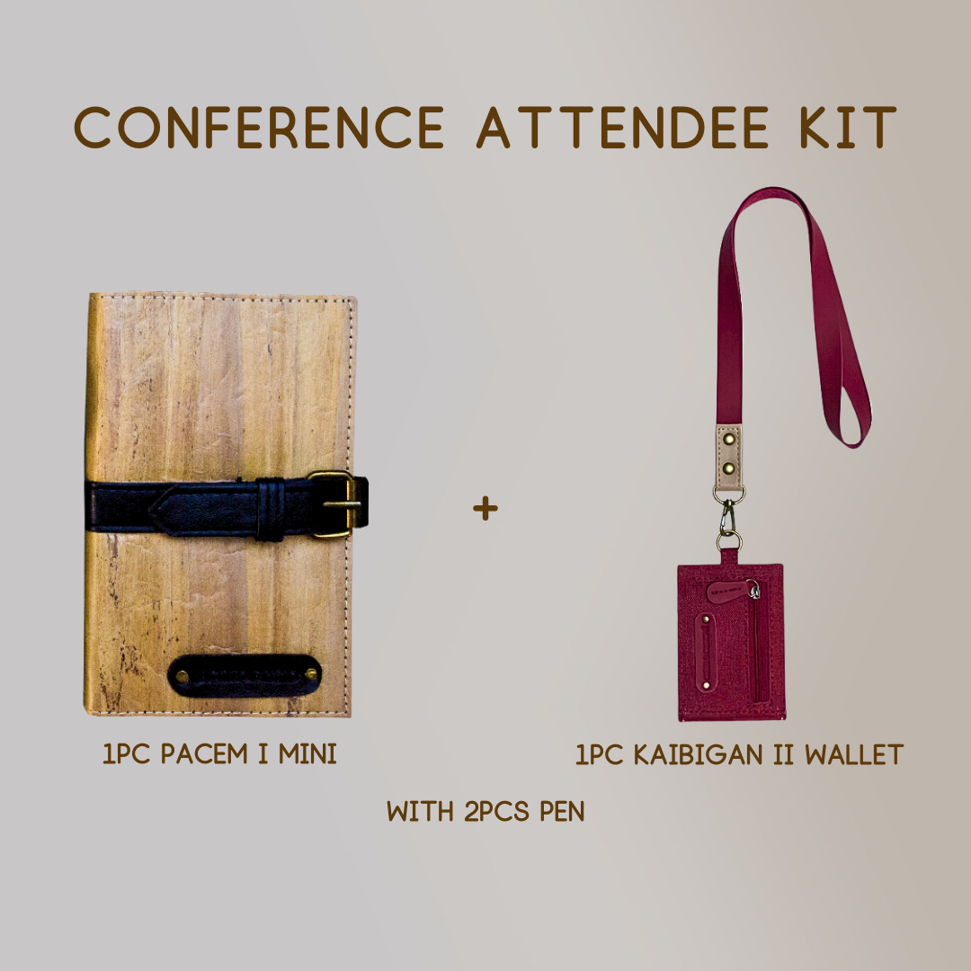 A mini vegan leather journal with a black leather belt buckle closure paired with a wallet ID lanyard in color magenta, and two pens.