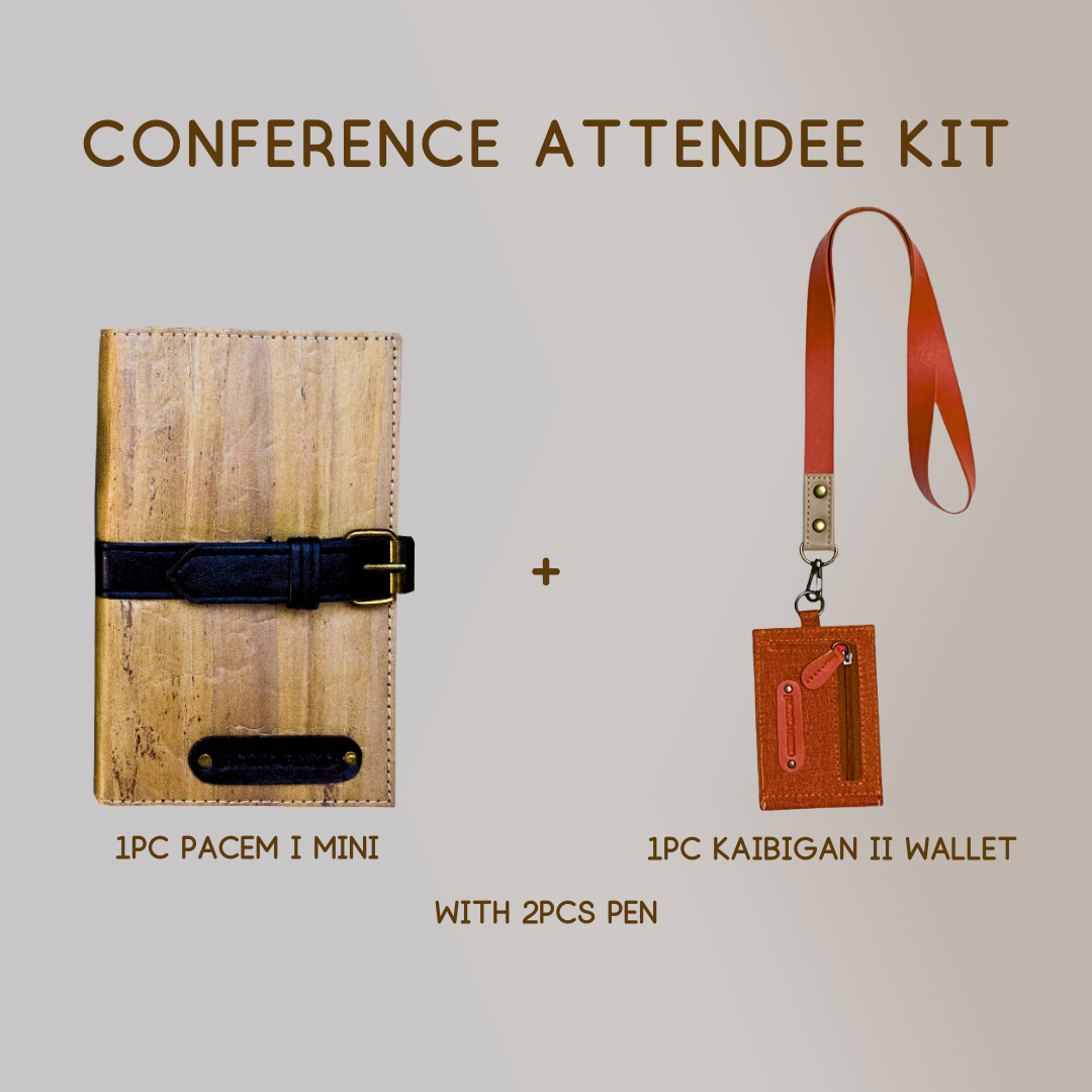 A mini vegan leather journal with a black leather belt buckle closure paired with a wallet ID lanyard in color orange, and two pens.